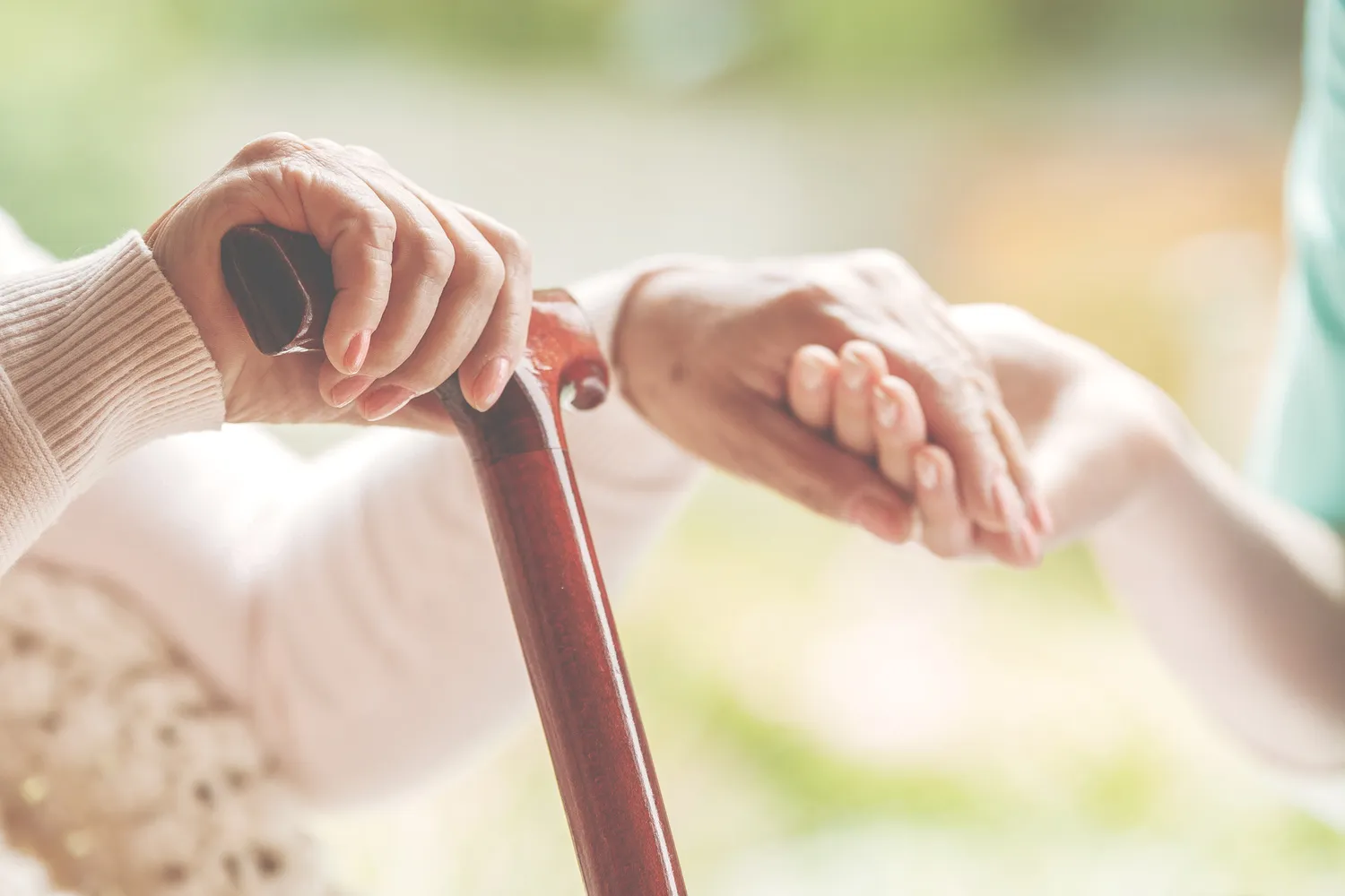 Curano Alltagsbegleitung - Gesundheitsdienst - Pflegekraft mit Brille gibt einer älteren Dame Vitamine