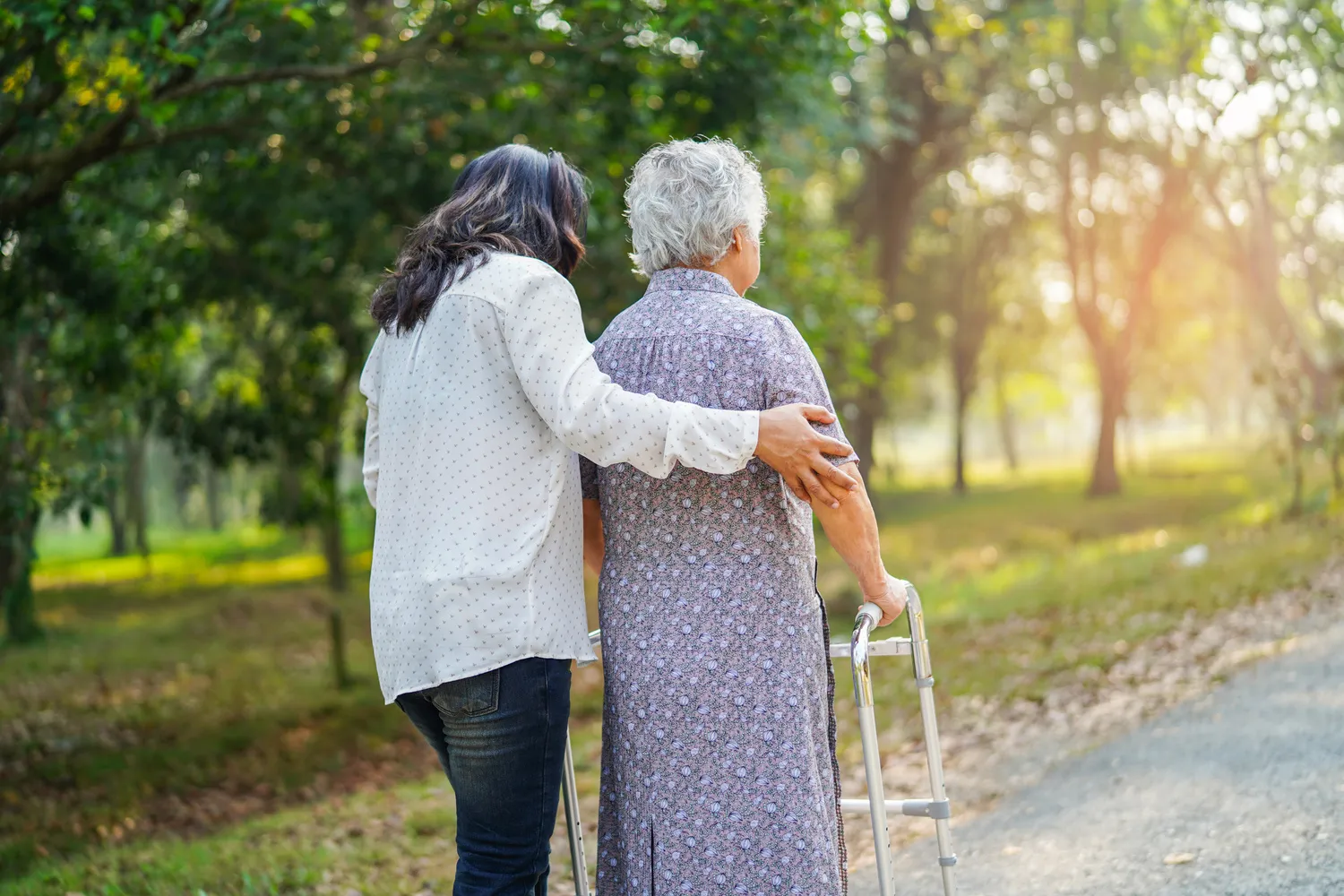 Curano Alltagsbegleitung – Gesundheitsdienst – Hilfe und Pflege Asiatische Senioren oder ältere alte Damen benutzen einen Gehhilfe mit guter Gesundheit, während sie in einem schönen, frischen Urlaub im Park spazieren gehen.